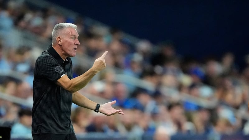 Sporting Kansas City manager Peter Vermes talks to his players during the first half of an MLS...