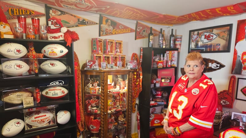 Melinda Hudgens gazes at her Chiefs collection inside her Independence home.