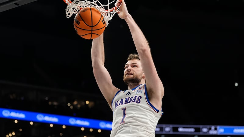 Kansas' Hunter Dickinson (1) dunks during overtime of an NCAA college basketball game against...