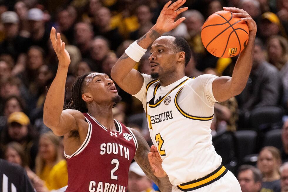 Missouri's Tamar Bates, right, passes the ball around South Carolina's Zachary Davis, left,...