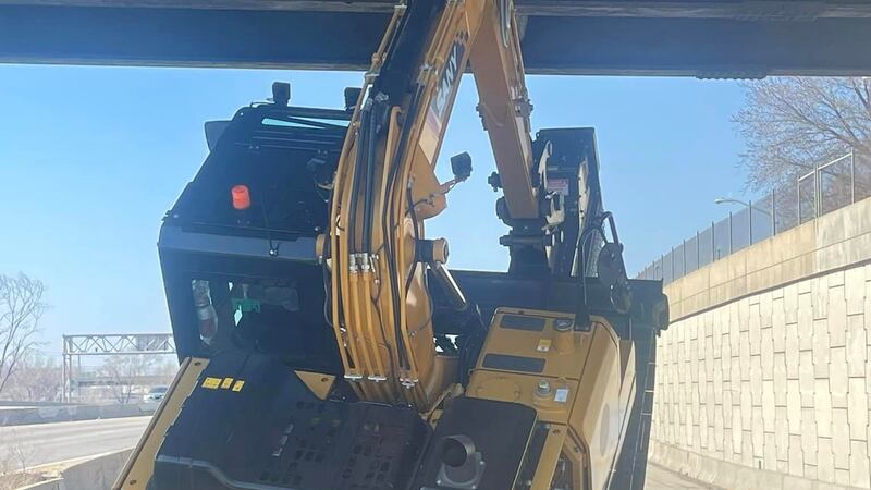 A truck carrying an excavator crashed into an overpass on westbound I-670 on Monday.