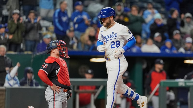 Kansas City Royals' Kyle Isbel (28) crosses the plate past Minnesota Twins catcher Christian...