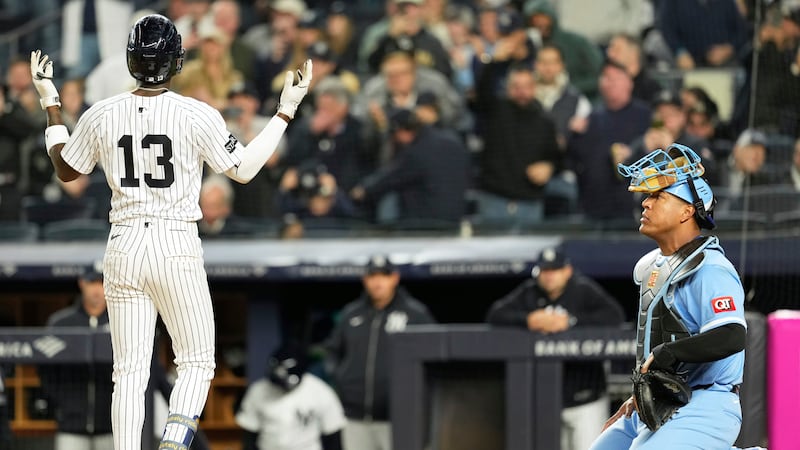 While Kansas City Royals catcher Salvador Perez, right, looks on, New York Yankees' Jazz...