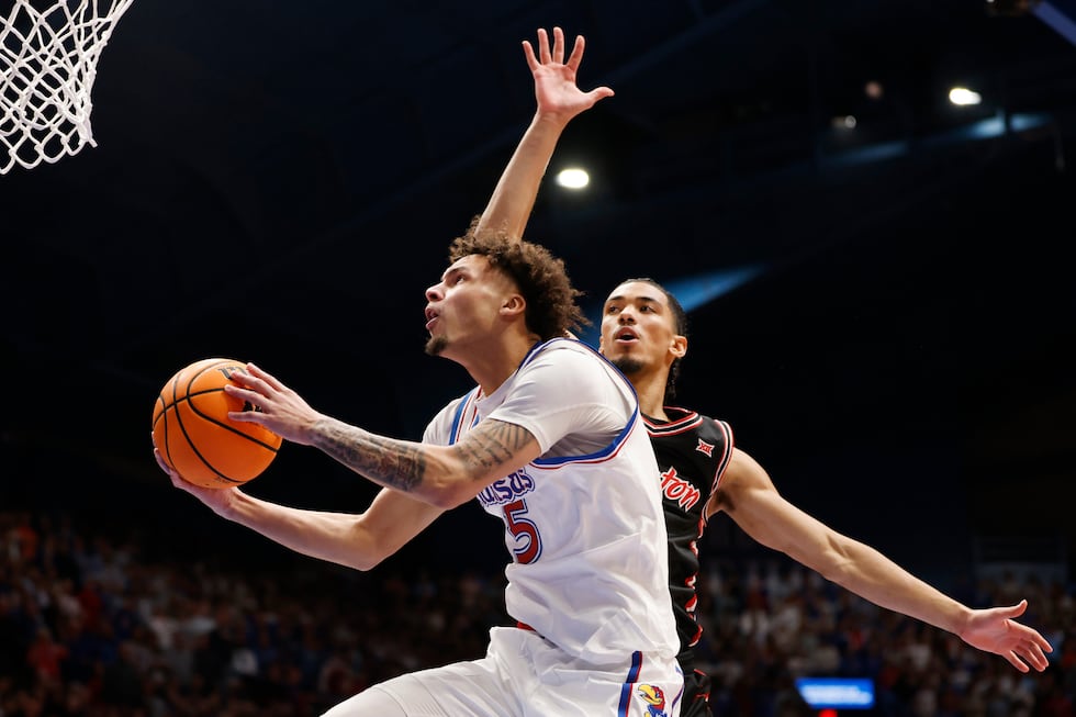 Kansas guard Zeke Mayo (5) goes up to score against Houston guard Milos Uzan, right, during...