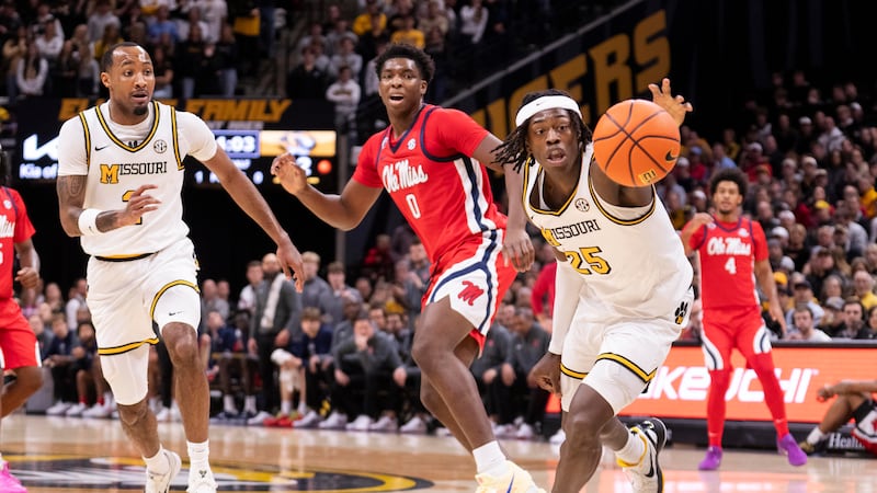 Missouri's Mark Mitchell, right, grabs a loose ball in front of Mississippi's Malik Dia (0)...