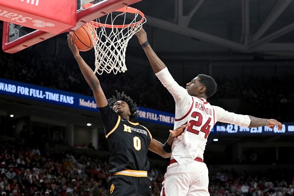 Missouri guard Anthony Robinson II (0) tries to drive past Arkansas forward Billy Richmond III...