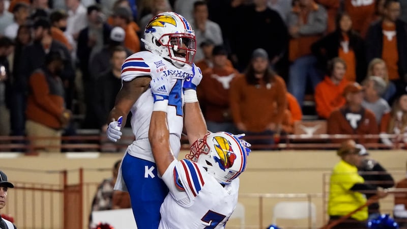 Kansas running back Devin Neal (4) celebrates his touchdown run against Texas with teammate...