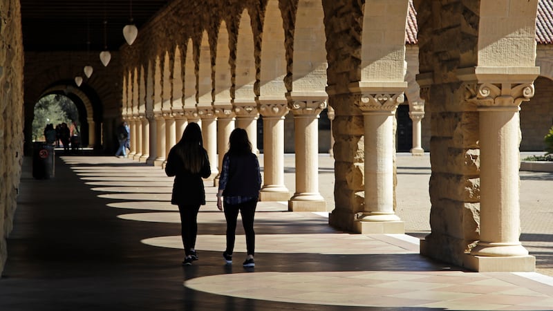 FILE - Students walk on the Stanford University campus, March 14, 2019, in Santa Clara, Calif....