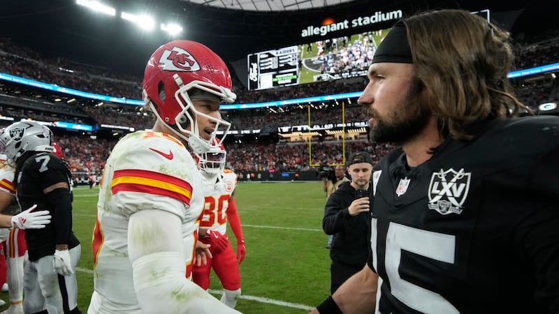 Kansas City Chiefs quarterback Patrick Mahomes, left, shakes hands with Las Vegas Raiders...