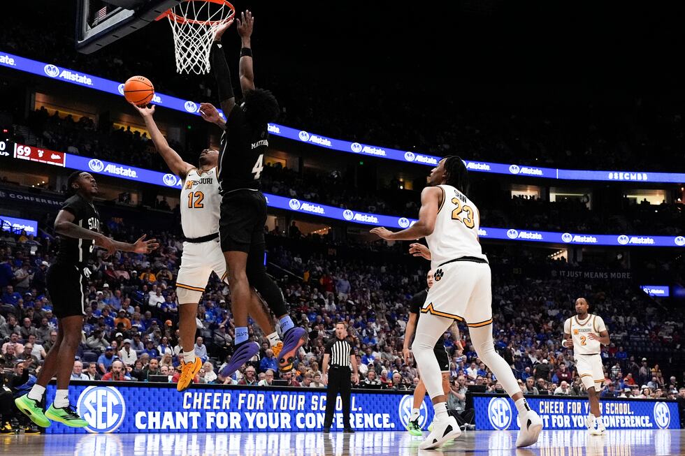 Missouri guard Tony Perkins (12) shoots against Mississippi State forward Cameron Matthews (4)...