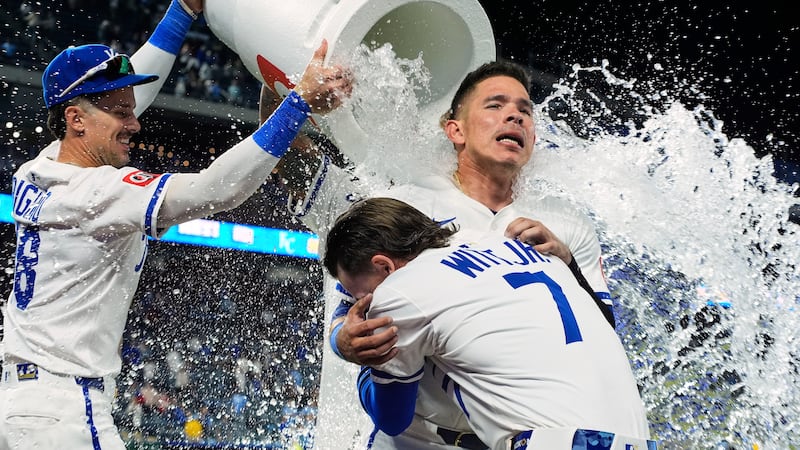 Kansas City Royals' Bobby Witt Jr. (7) and Freddy Fermin are doused by teammates after their...